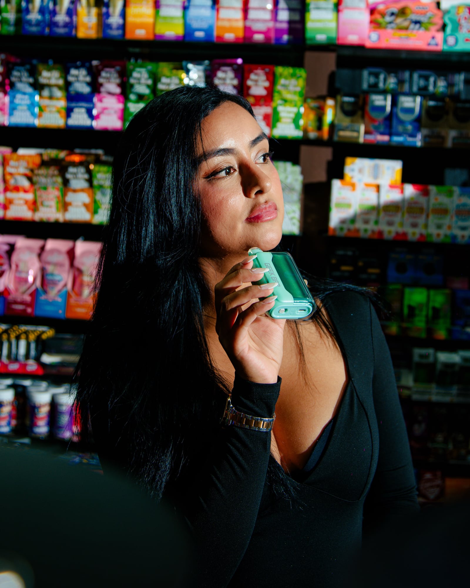A woman holding a green device in front of colorful retail displays at Zona Verde.