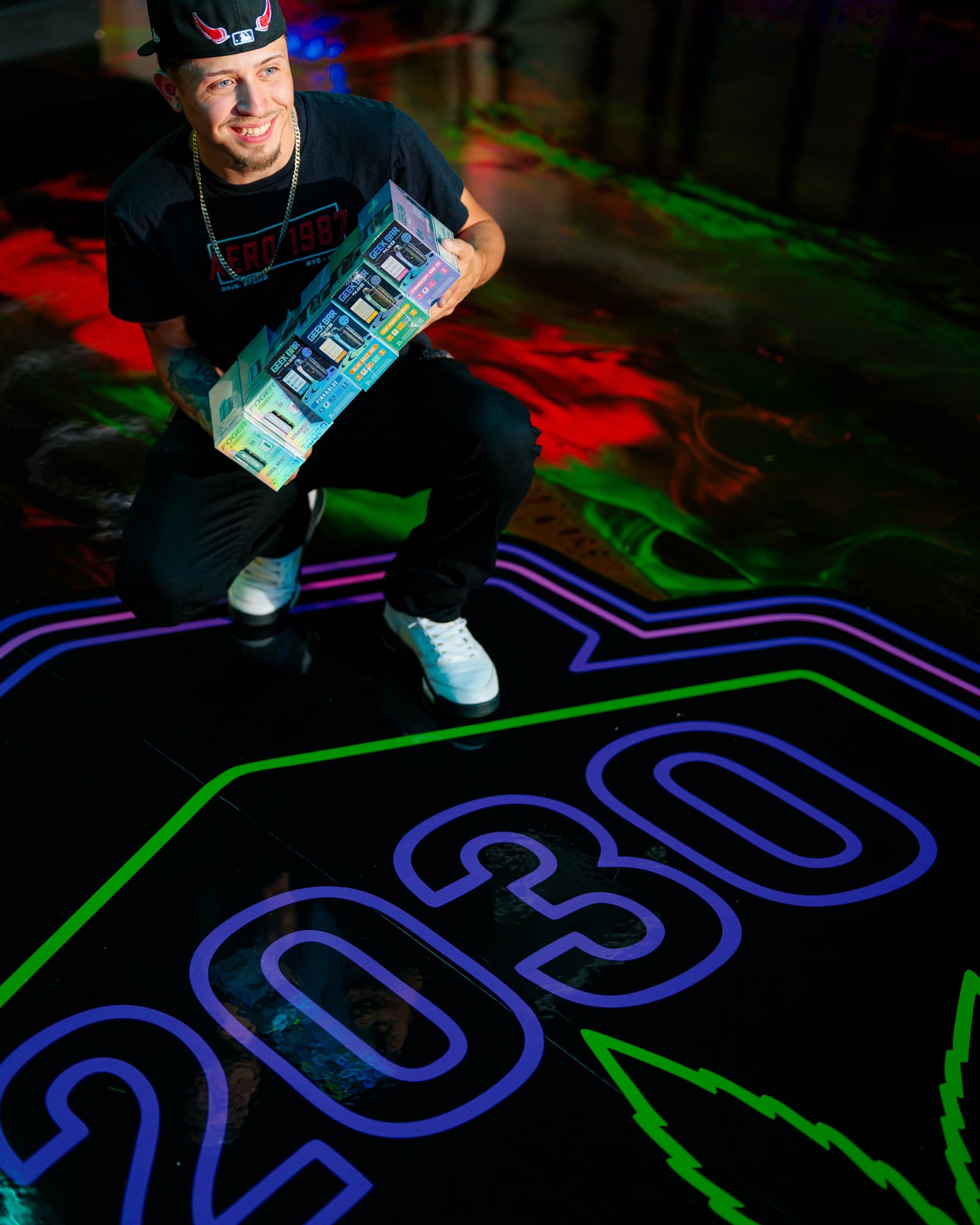A visitor holding boxed products inside Zona Verde, with a colorful floor below.